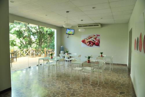 un comedor con mesas y sillas y una gran ventana en G y V Hotels, en Tegucigalpa