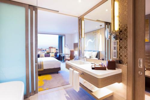 a hotel room with a bathroom and a bed and a sink at Crowne Plaza Vientiane by IHG in Vientiane