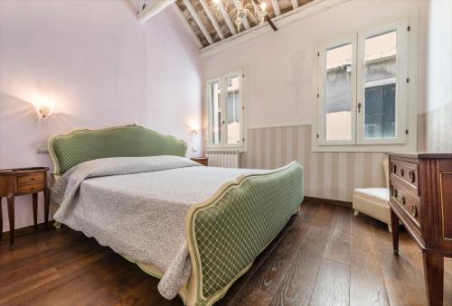 a bedroom with a green bed and a window at Appartamento Biennale in Venice