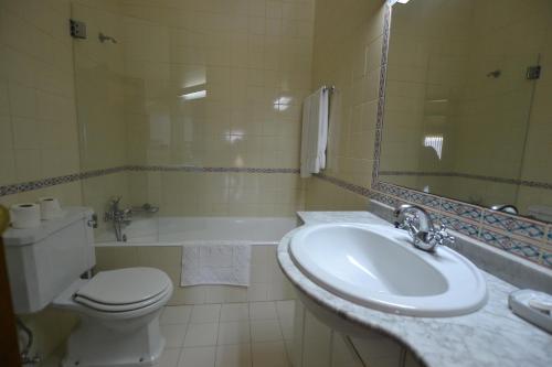 a bathroom with a sink and a toilet and a tub at Quinta de São Bento in Vila de Prado