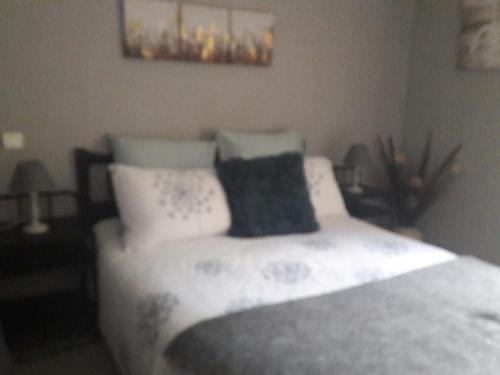 a bedroom with a bed with white sheets and pillows at Au Bras d'Argent in Berthez