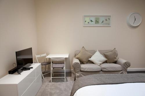 um quarto com uma cama, um sofá e uma mesa em Toothbrush Apartments - Ipswich Central East em Ipswich