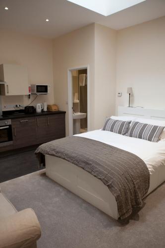 a bedroom with a large bed and a kitchen at Toothbrush Apartments - Ipswich Central East in Ipswich