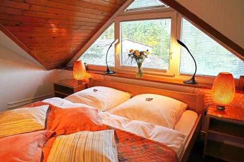 a bedroom with a bed with two lamps and a window at Apartments Poldi in Bled