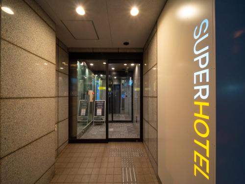 an entrance to a store with a sign on the wall at Super Hotel Namba Nipponbashi in Osaka