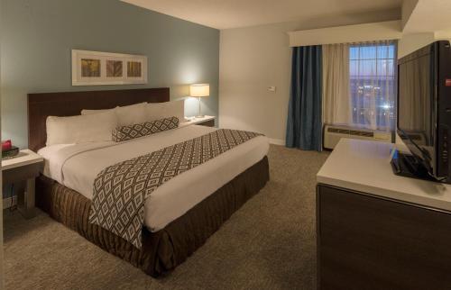 a hotel room with a bed and a television at Crowne Plaza Hotel and Suites Pittsburgh South by IHG in Pittsburgh