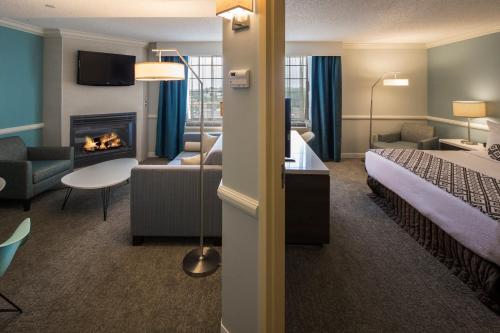 a hotel room with a bed and a fireplace at Crowne Plaza Hotel and Suites Pittsburgh South by IHG in Pittsburgh