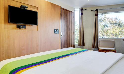 a bedroom with a rainbow bed and a flat screen tv at Hotel Sun Grand in Dehradun