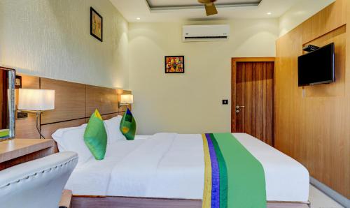 a bedroom with a white bed and a television at Hotel Sun Grand in Dehradun