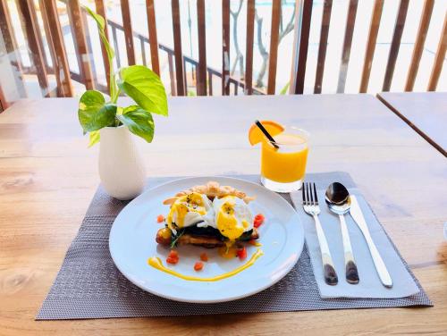 een bord eten op een tafel met een glas sinaasappelsap bij The Salila Beach Resort in Seminyak