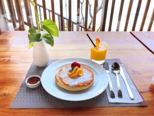 een bord met gebak op een tafel met een drankje bij The Salila Beach Resort in Seminyak