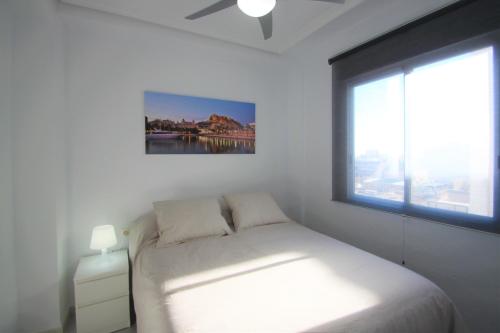 a white bedroom with a bed and a window at CasaTuris Rambla Méndez Núñez en el corazón de Alicante A109 in Alicante