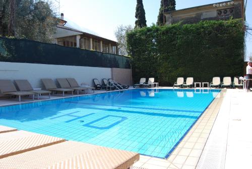 a large swimming pool with chairs at Hotel Diana in Malcesine