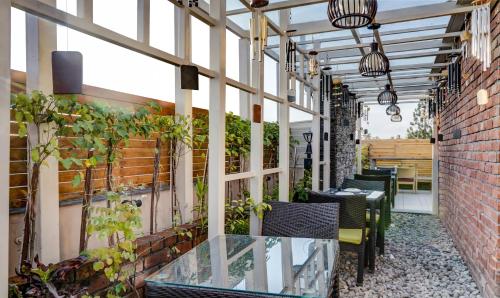 an outdoor patio with tables and chairs and plants at Hotel Sun Grand in Dehradun