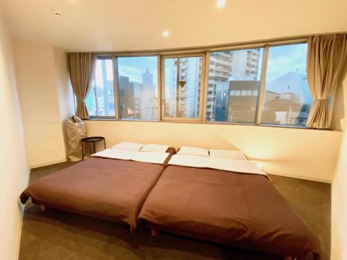 a large bed in a room with a large window at Osaka Guesthouse Nest in Osaka