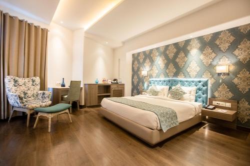 um quarto com uma cama, uma secretária e uma cadeira em AB Clarks Inn Jalandhar em Jalandhar
