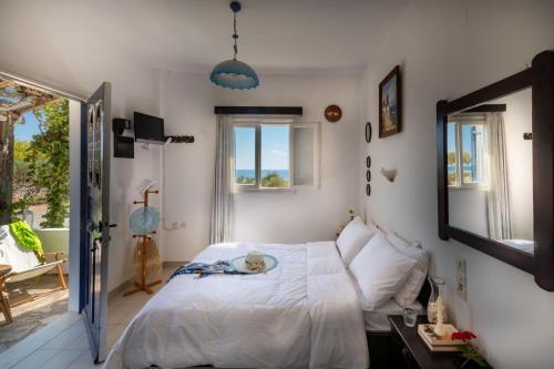 a bedroom with a bed and a mirror and a window at Margarita Apartments in Ierapetra