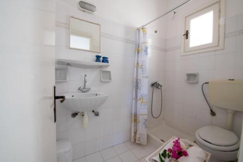 a bathroom with a toilet and a sink and a shower at Margarita Apartments in Ierápetra