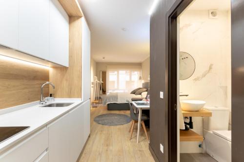 uma cozinha com um lavatório e uma mesa num quarto em HiBilbao Apartments em Bilbao