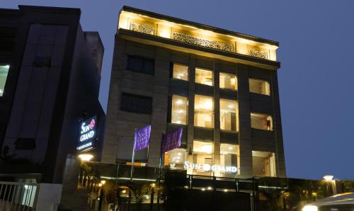 a tall building with lights on it at night at Hotel Sun Grand in Dehradun