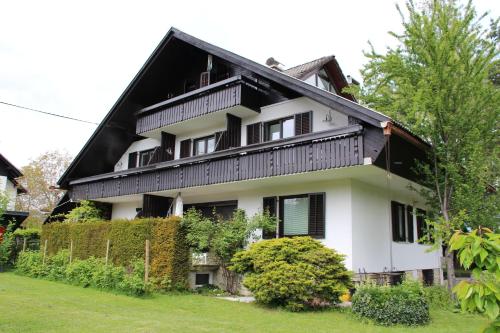 a large white house with a black roof at Apartments Poldi in Bled