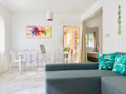 a living room with a couch and a table and chairs at Beachfront Villa in a beautiful and secured complex in Flic-en-Flac
