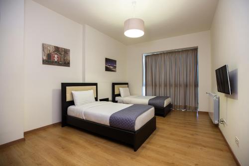 ein Hotelzimmer mit 2 Betten und einem Flachbild-TV in der Unterkunft Kantari Suites in Beirut