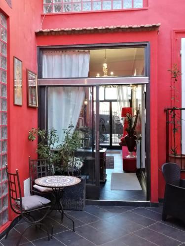 a red building with a glass door and a table at Al 20 Guest House Fiera Milano - Certosa - San Siro in Milan