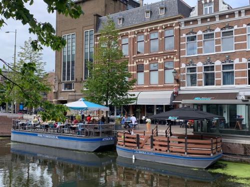 two boats on a river in a city at Apartement City Centre with roof terrace and parking with additional costs in The Hague