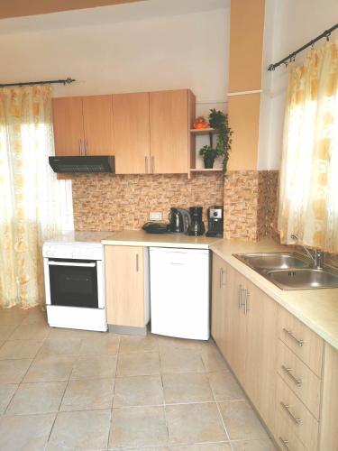a kitchen with a sink and a stove top oven at Villa PANGALIS Romantica in Kato Pavliana