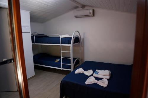 een kleine kamer met een bed en twee stapelbedden bij Villaggio Residence Torre Saracena in Marina di Camerota
