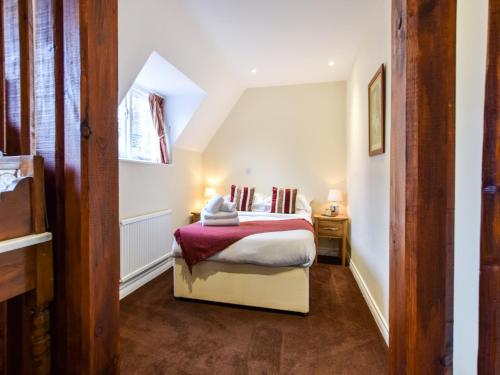 a bedroom with a bed with a red and white blanket at Anne Boleyn in Winchcombe