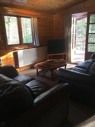 a living room with a couch and a coffee table at Chalet in Tyndrum