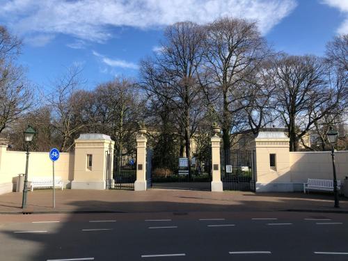 a gate to a building with trees in the background at Apartement City Centre with roof terrace and parking with additional costs in The Hague