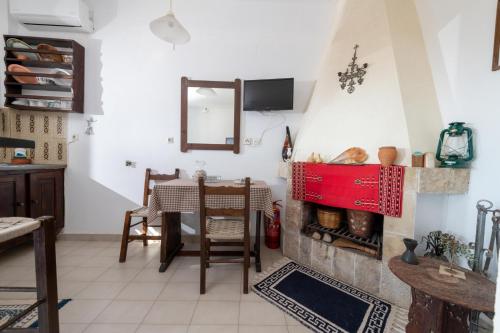a living room with a table and a fireplace at Margarita Apartments in Ierápetra