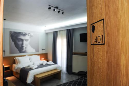 a hotel room with a bed and a clock on the wall at Alexandros in Giannitsa