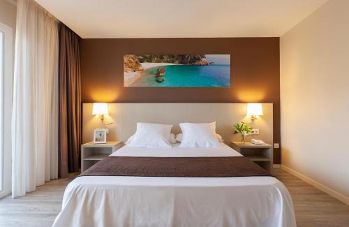 a hotel room with a bed and a view of the ocean at Helios Benidorm in Benidorm