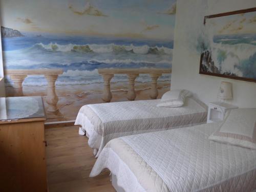 two beds in a room with a painting on the wall at Azuré Chambres d'hôtes in Orgeval