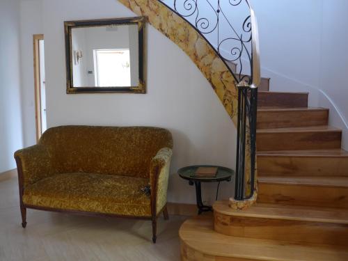 a chair in a room with a mirror and stairs at Azuré Chambres d'hôtes in Orgeval
