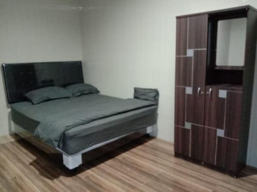 ein Schlafzimmer mit einem Bett und eine Kommode mit einem Spiegel in der Unterkunft Villa Lim in Tabanan