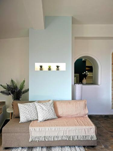 a living room with a couch and a blue wall at Villa PANGALIS Romantica in Kato Pavliana