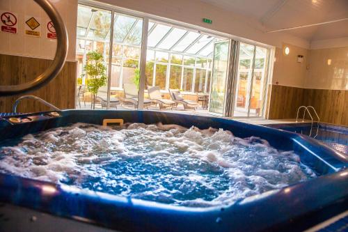 a large blue tub filled with water in a room at Heywood Spa Hotel in Tenby