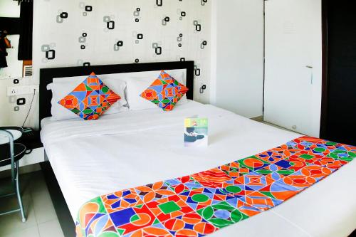 a bed with a colorful comforter and pillows on it at FabHotel Eleanora Inn New Town in Kolkata