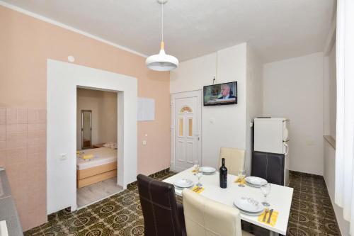 una sala da pranzo con tavolo e sedie bianchi di Apartments Makarska Gudelj Cvitan a Makarska
