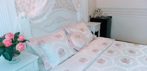 a bed with pink and white sheets and pillows at Shalanda in Odesa