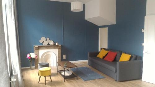 a living room with a couch and a fireplace at Sainte Cécile in Boulogne-sur-Mer