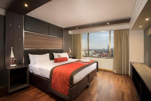 1 dormitorio con cama grande y ventana grande en Boulevard Suites Ferrat, en Santiago