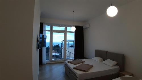 une chambre avec un lit et une grande fenêtre dans l'établissement Villa Roan, à Bar