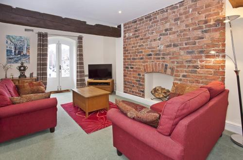 sala de estar con 2 sofás rojos y chimenea de ladrillo en River View, en York