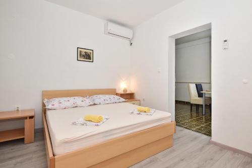 a bedroom with a bed with two towels on it at Apartments Makarska Gudelj Cvitan in Makarska